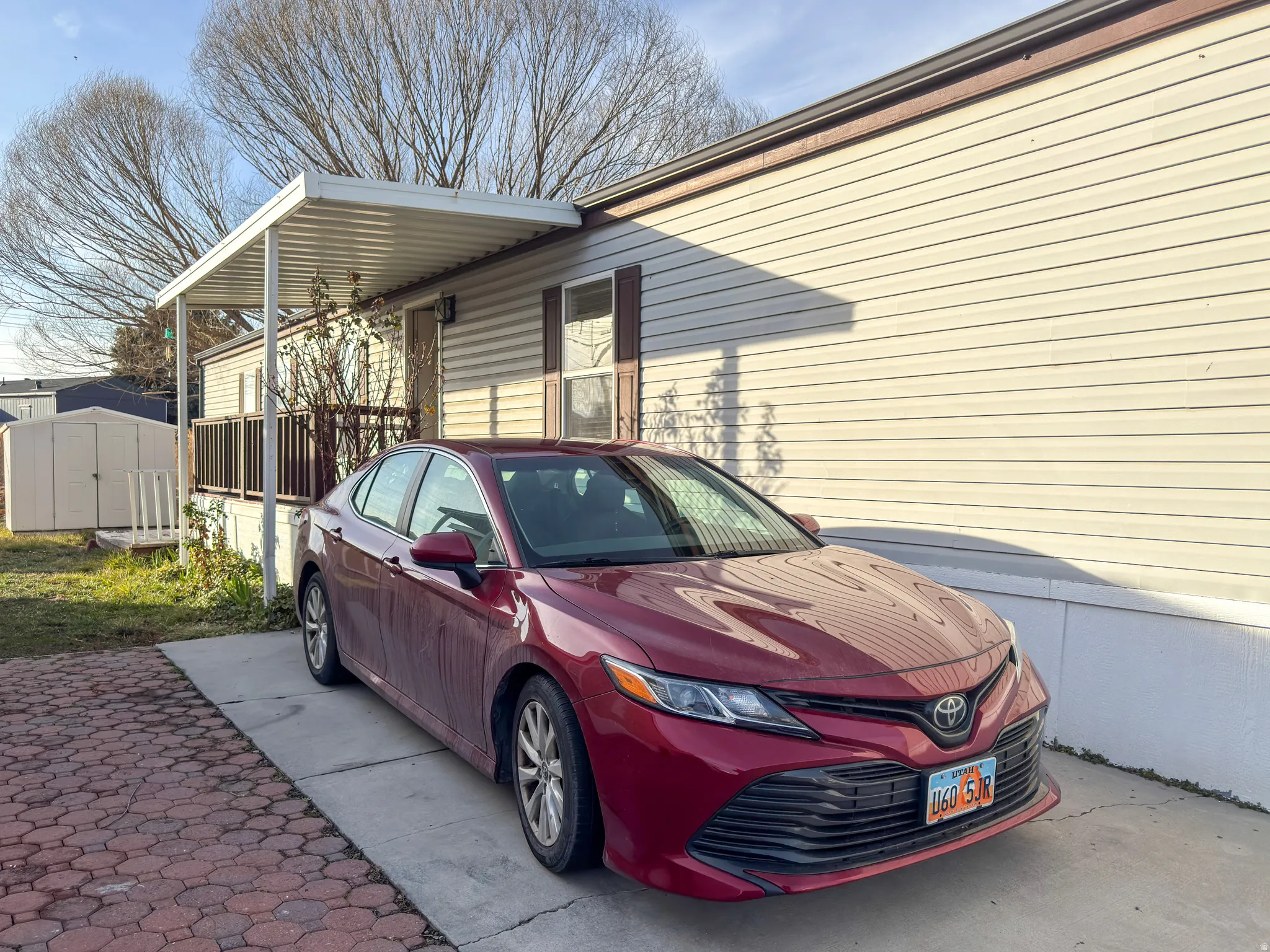 View of side of home featuring a shed