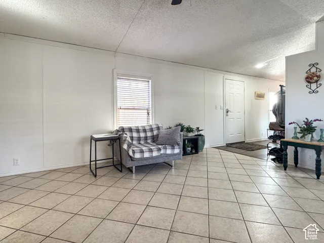 Living room featuring a textured ceiling and light tile patterned floors
