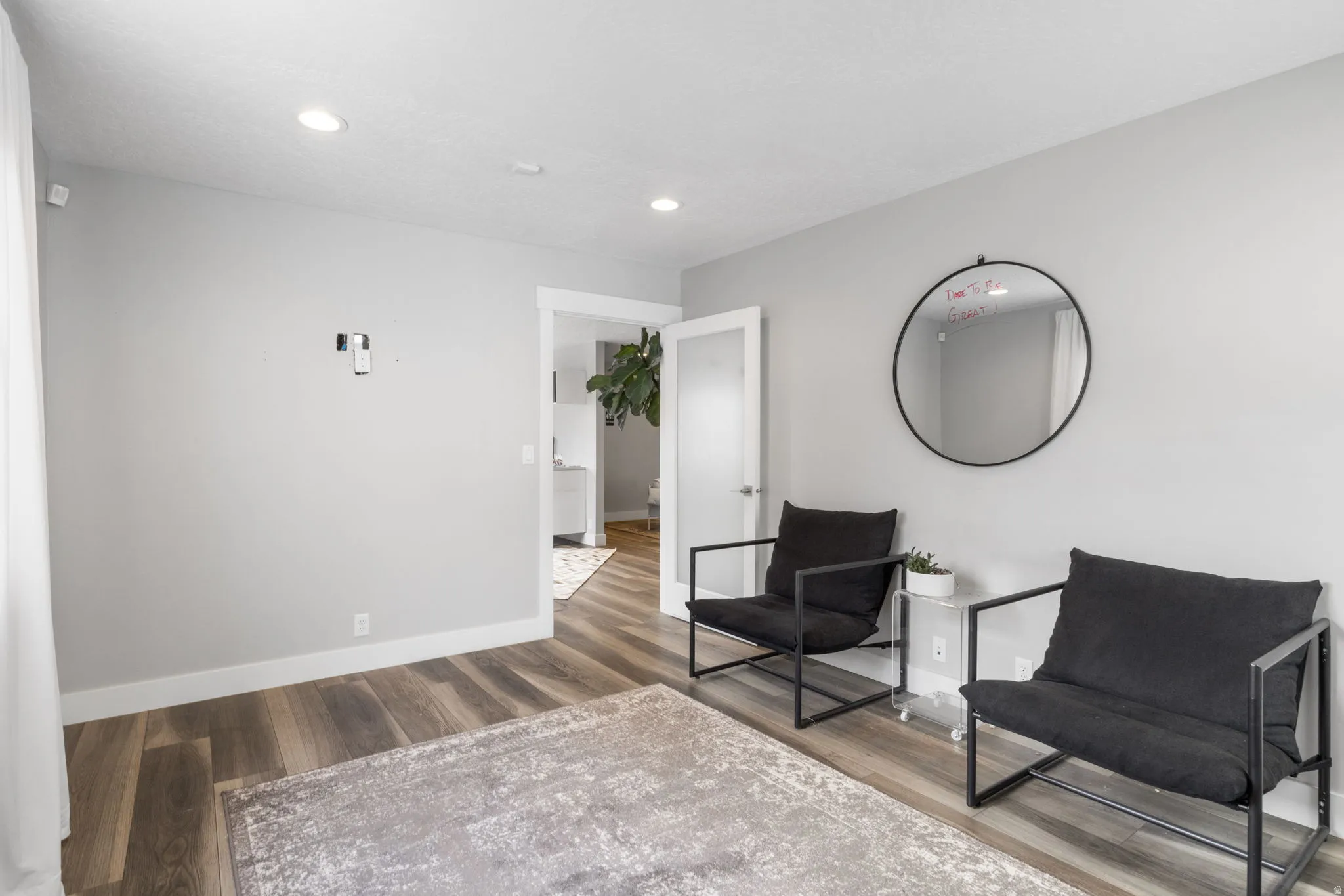 Living area with wood finished floors and recessed lighting