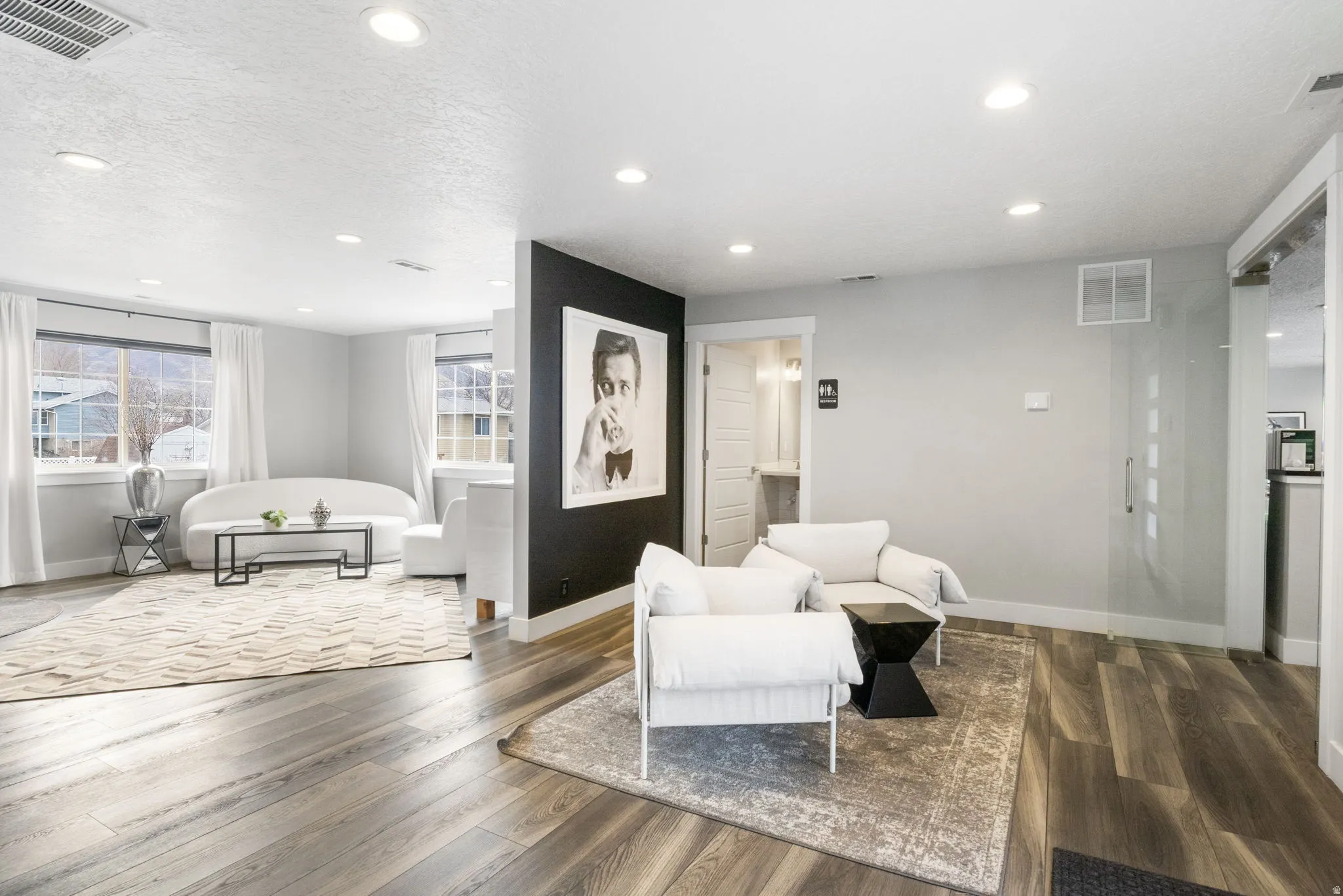 Sitting room with recessed lighting, wood finished floors, and a textured ceiling