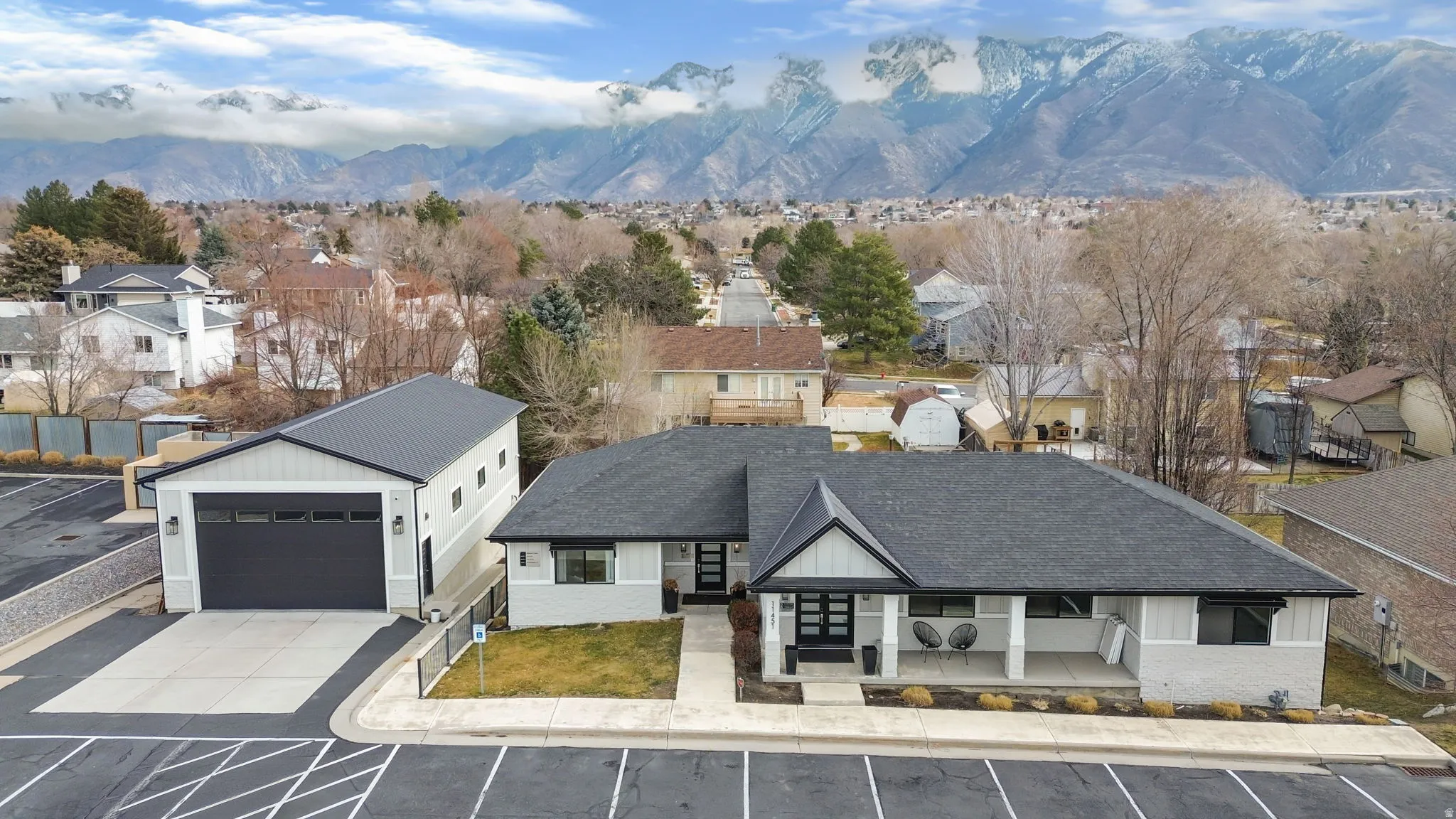 View of front of property with a shingled roof, a mountain view, a porch, and a residential view