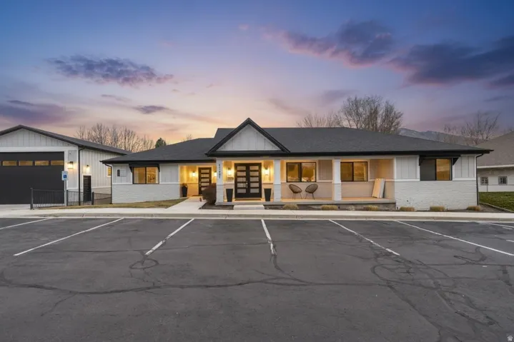 Property at dusk featuring uncovered parking