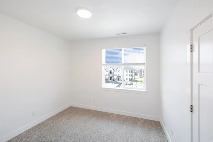 Neutral wall palette, recessed lighting, window with blinds, carpeted flooring, and a paneled door