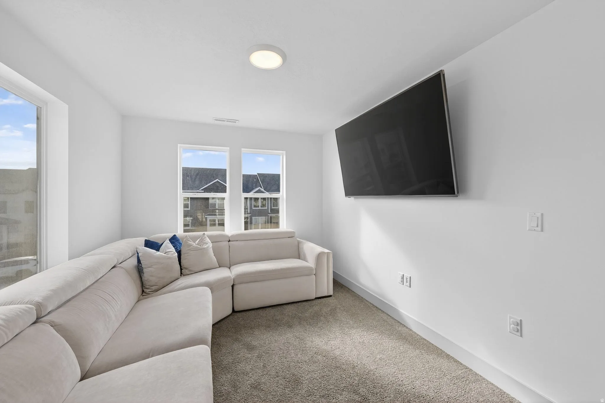 Carpeted living area featuring baseboards