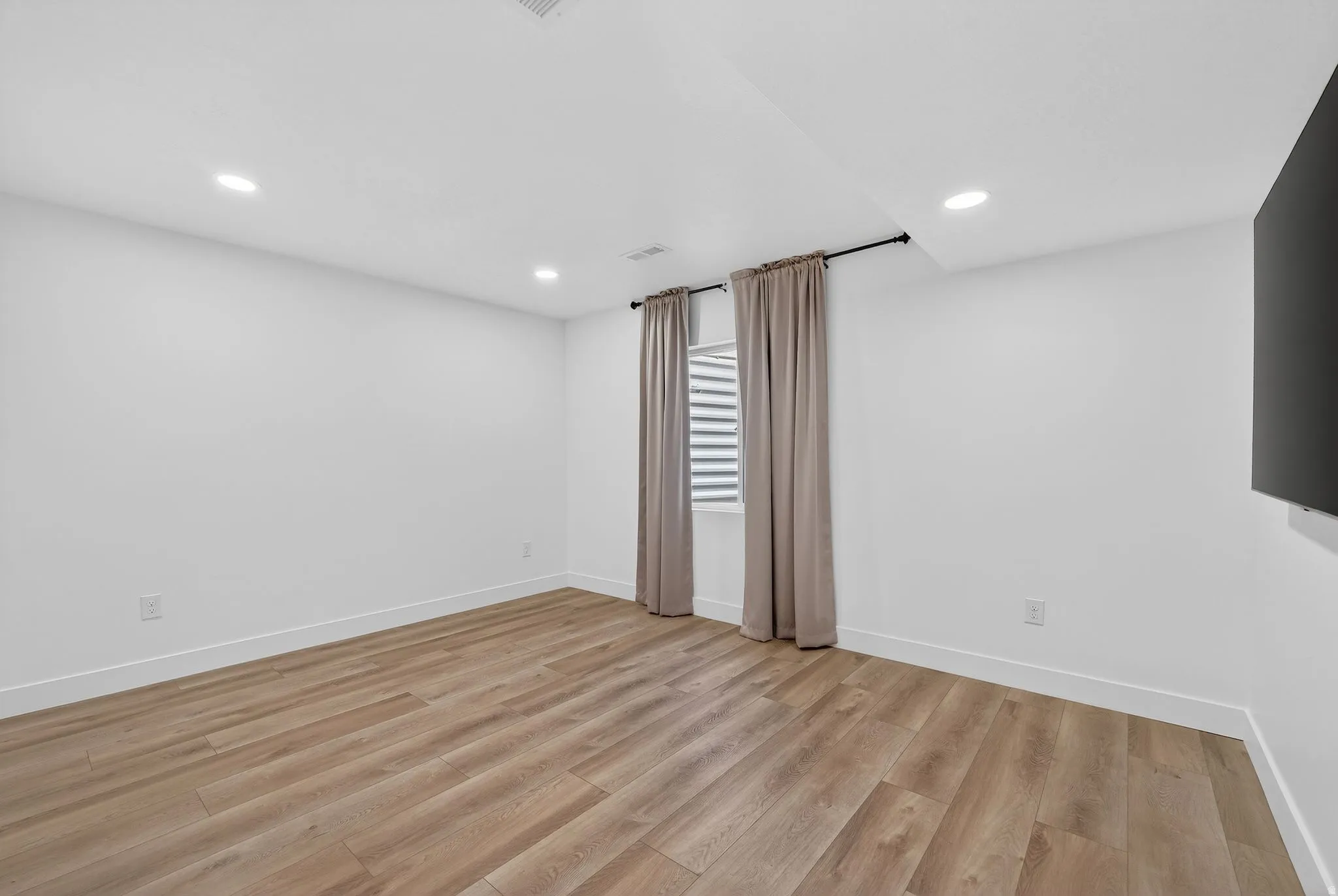 Spare room with light wood-type flooring and recessed lighting