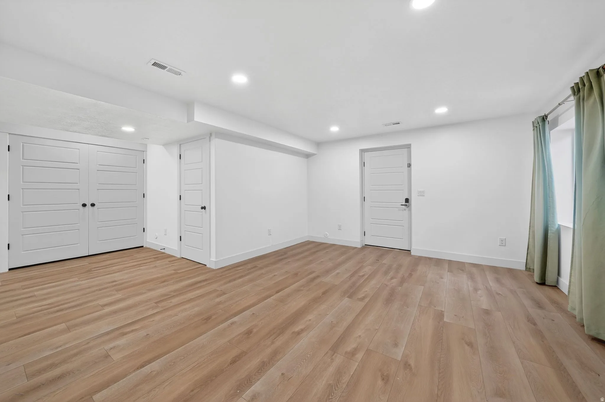 Unfurnished living room featuring light wood finished floors and recessed lighting