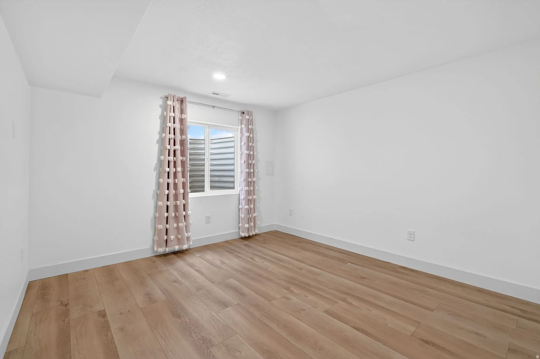Unfurnished room featuring light wood-style flooring and baseboards
