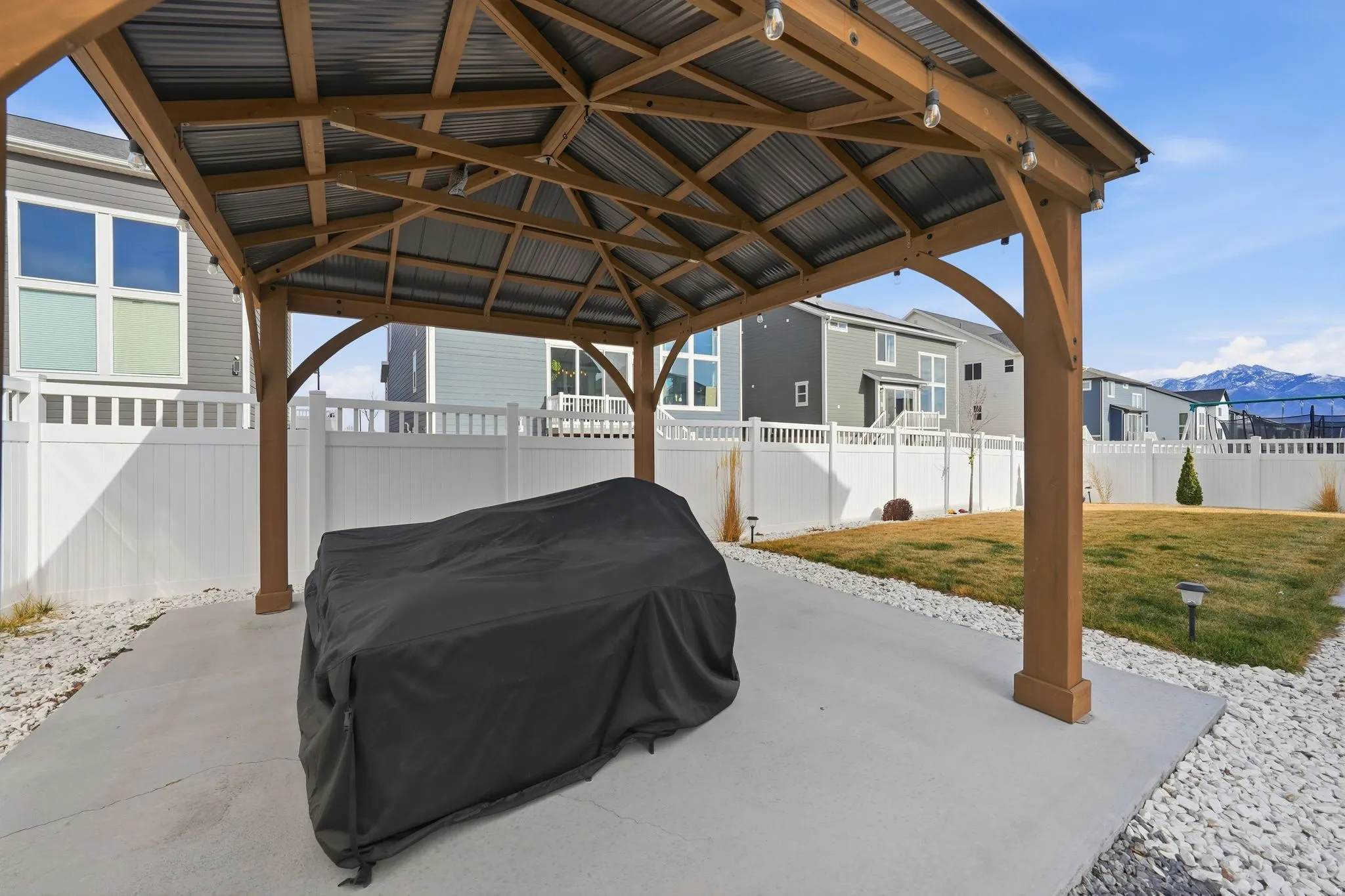Fenced backyard featuring a gazebo, a patio area, and a mountain view