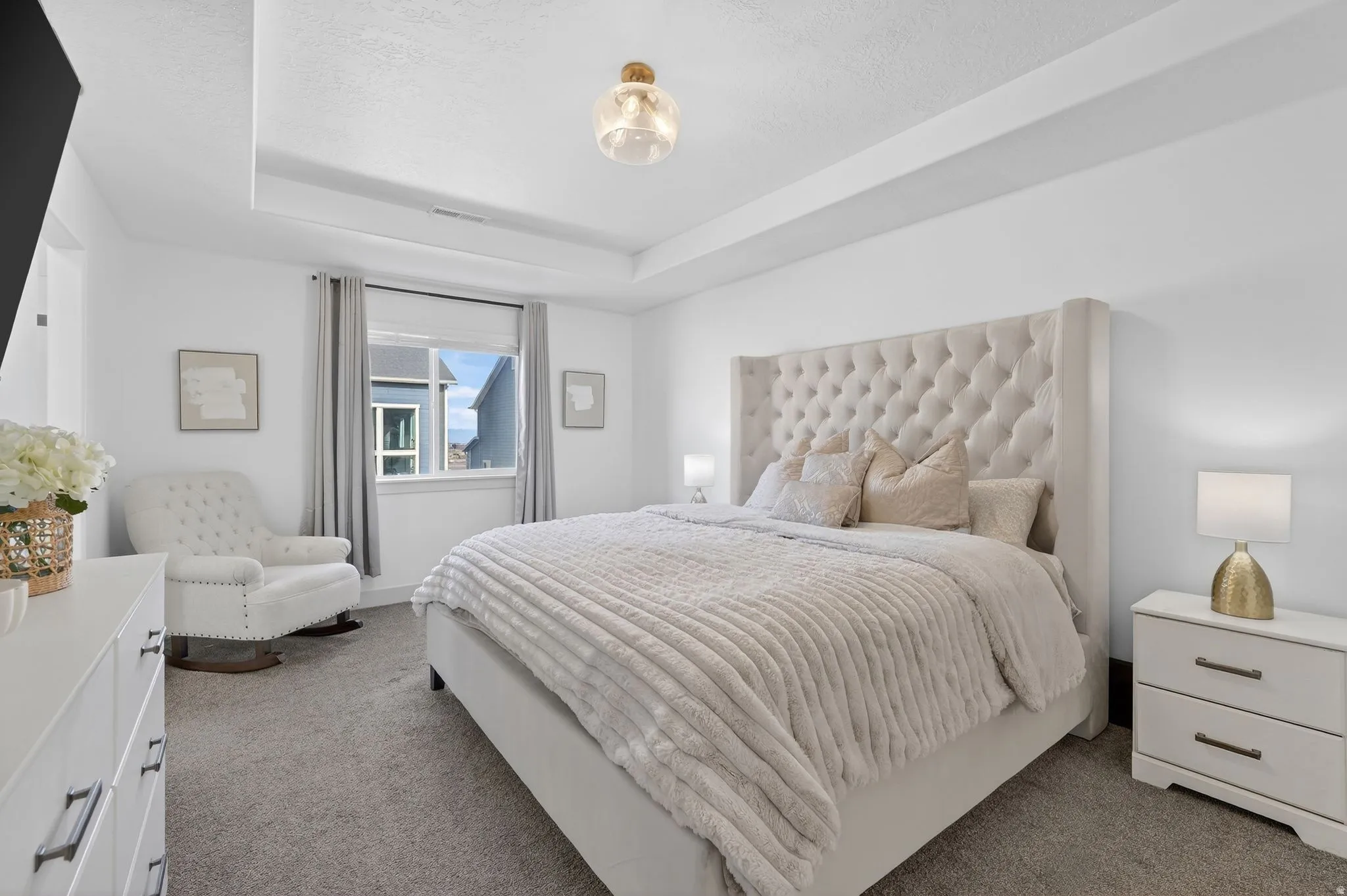Bedroom featuring a tray ceiling and dark colored carpet