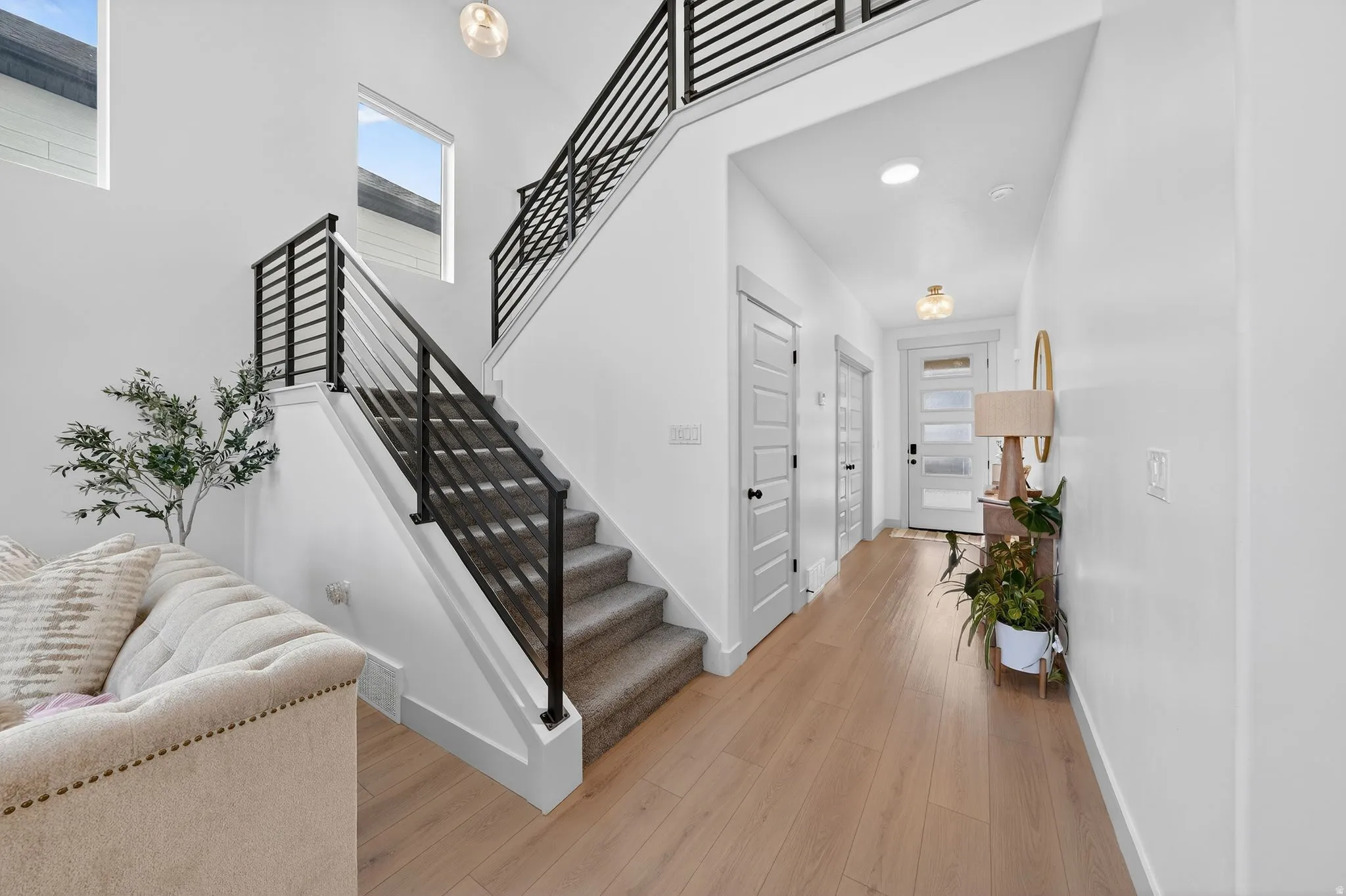 Stairway with wood finished floors and a high ceiling