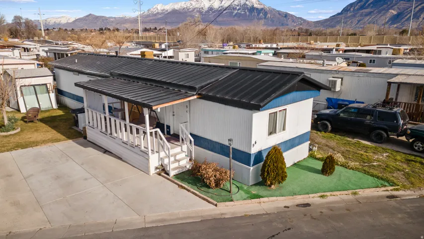 View of front facade featuring a metal roof, a residential view, a mountain view, a front yard, and covered porch