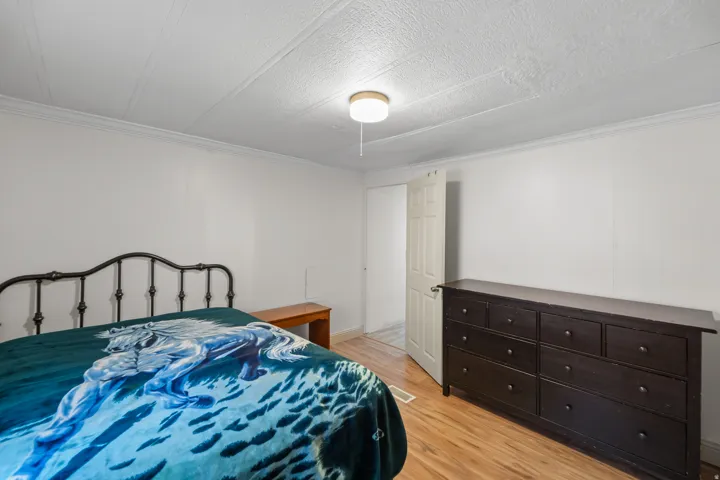 Bedroom with light wood-style floors and ornamental molding