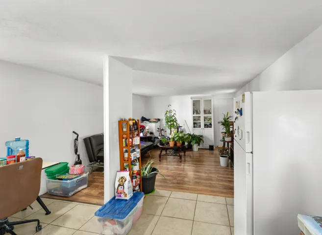 Kitchen with freestanding refrigerator and light tile patterned floors