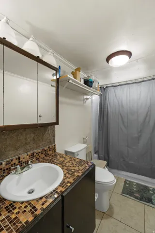 Full bath featuring vanity and light tile patterned floors