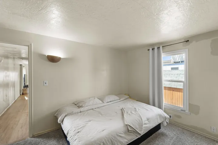 Bedroom with a textured ceiling and carpet
