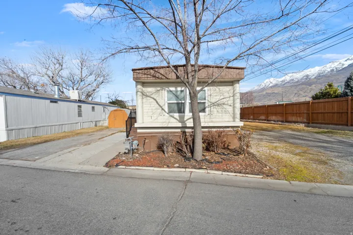 View of front of home with a mountain view and driveway