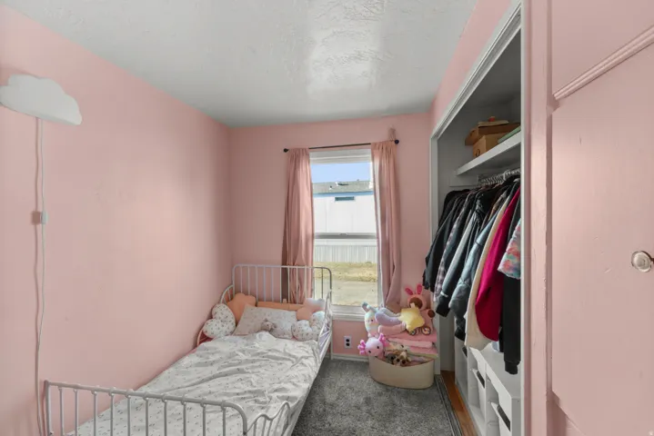 Bedroom with dark carpet, a closet, and a textured ceiling