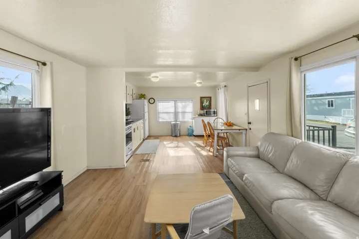 Living room featuring healthy amount of natural light, light wood finished floors, and a textured ceiling