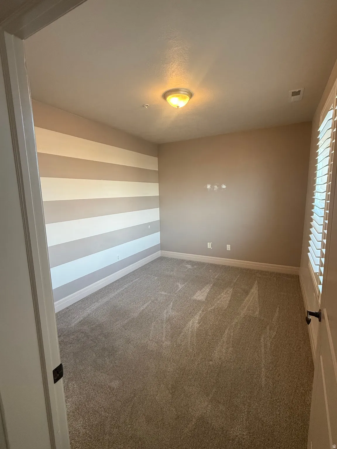 Spare room with carpet and baseboards