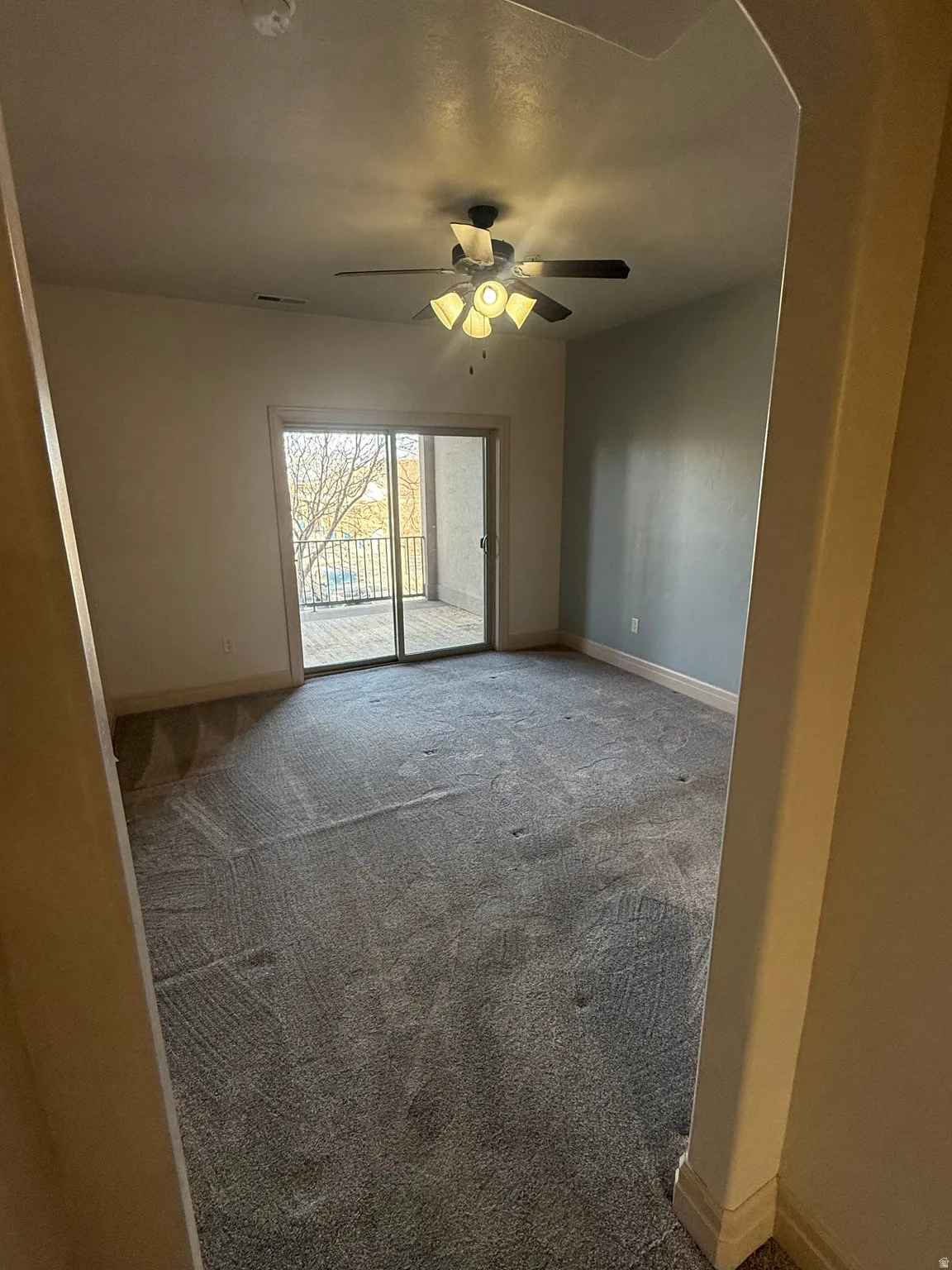 Empty room featuring carpet flooring and ceiling fan