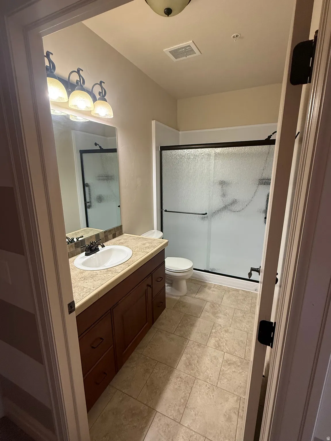 Full bath featuring a shower stall and vanity