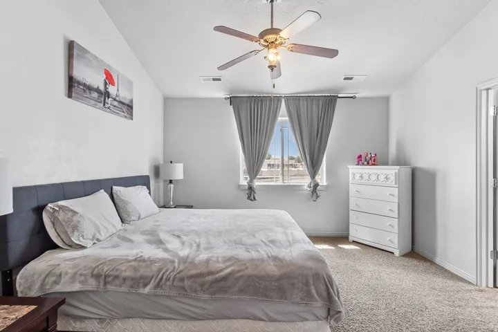Bedroom featuring carpet flooring, a ceiling fan, and a textured ceiling
