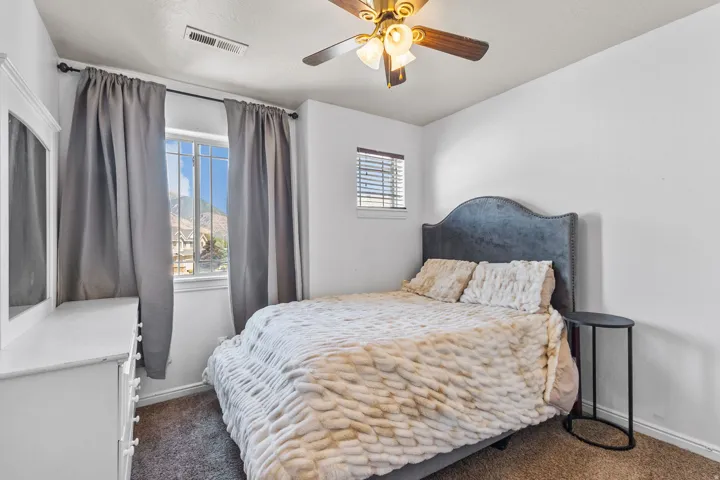 Bedroom featuring dark carpet, a ceiling fan, and a textured ceiling
