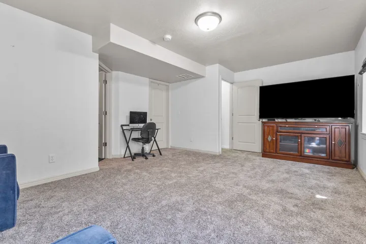 Living room featuring light carpet and a desk