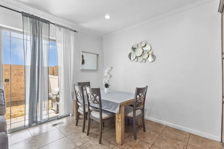 Dining room with ornamental molding and recessed lighting