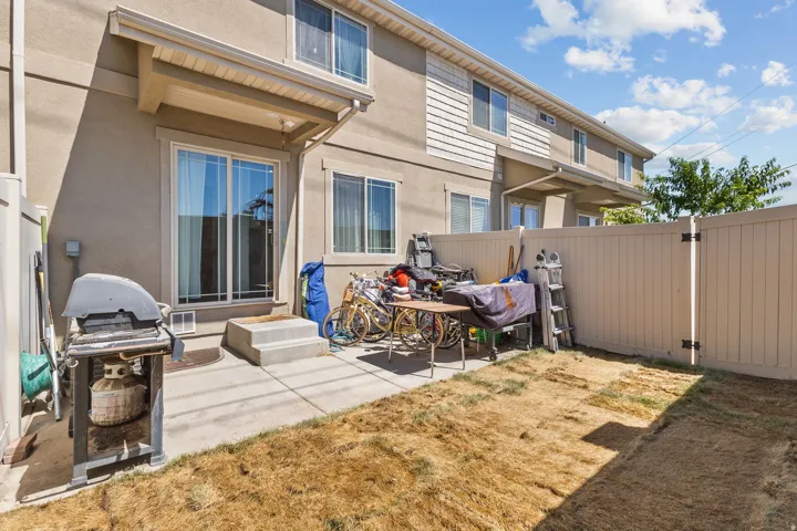 Rear view of house with stucco siding, a patio, and a gate