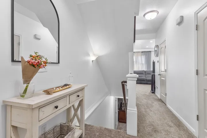 Hallway with an upstairs landing and carpet flooring