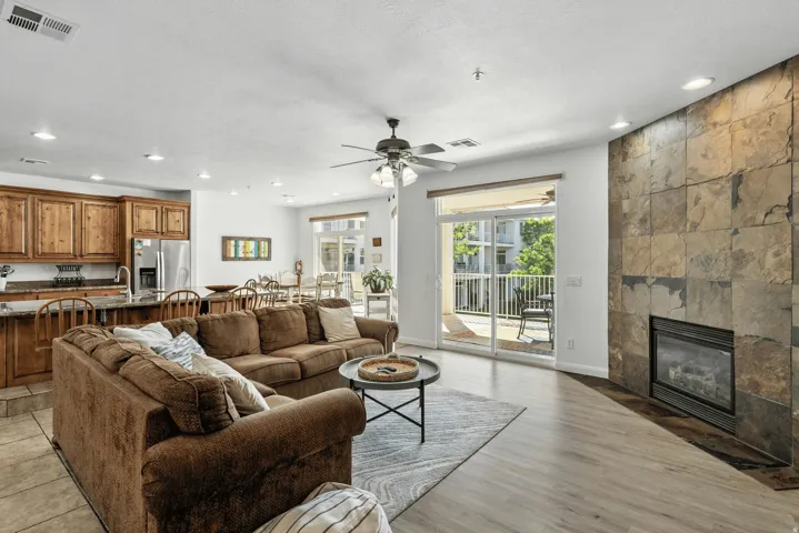 Living room with a fireplace, recessed lighting, a ceiling fan, and light wood-style floors