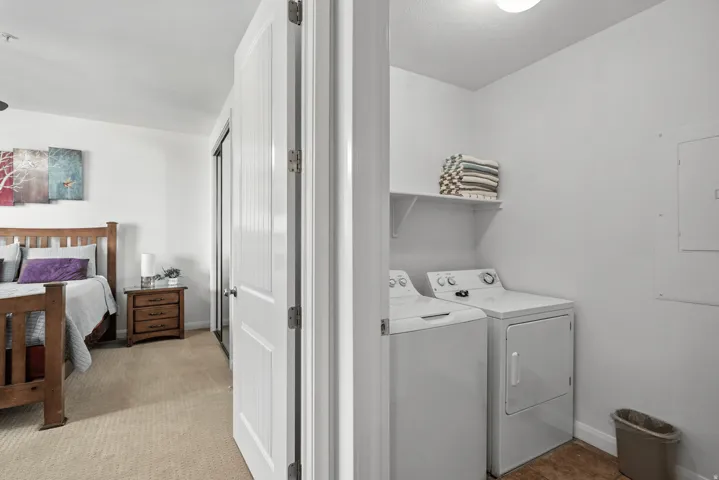 Laundry area featuring electric panel and washing machine and clothes dryer