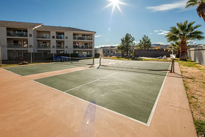 View of tennis court with community basketball court