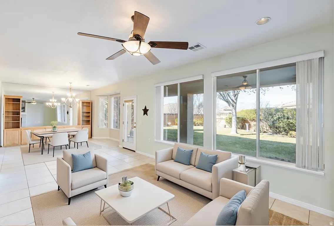 Living area featuring ceiling fan, light tile patterned floors, and a chandelier