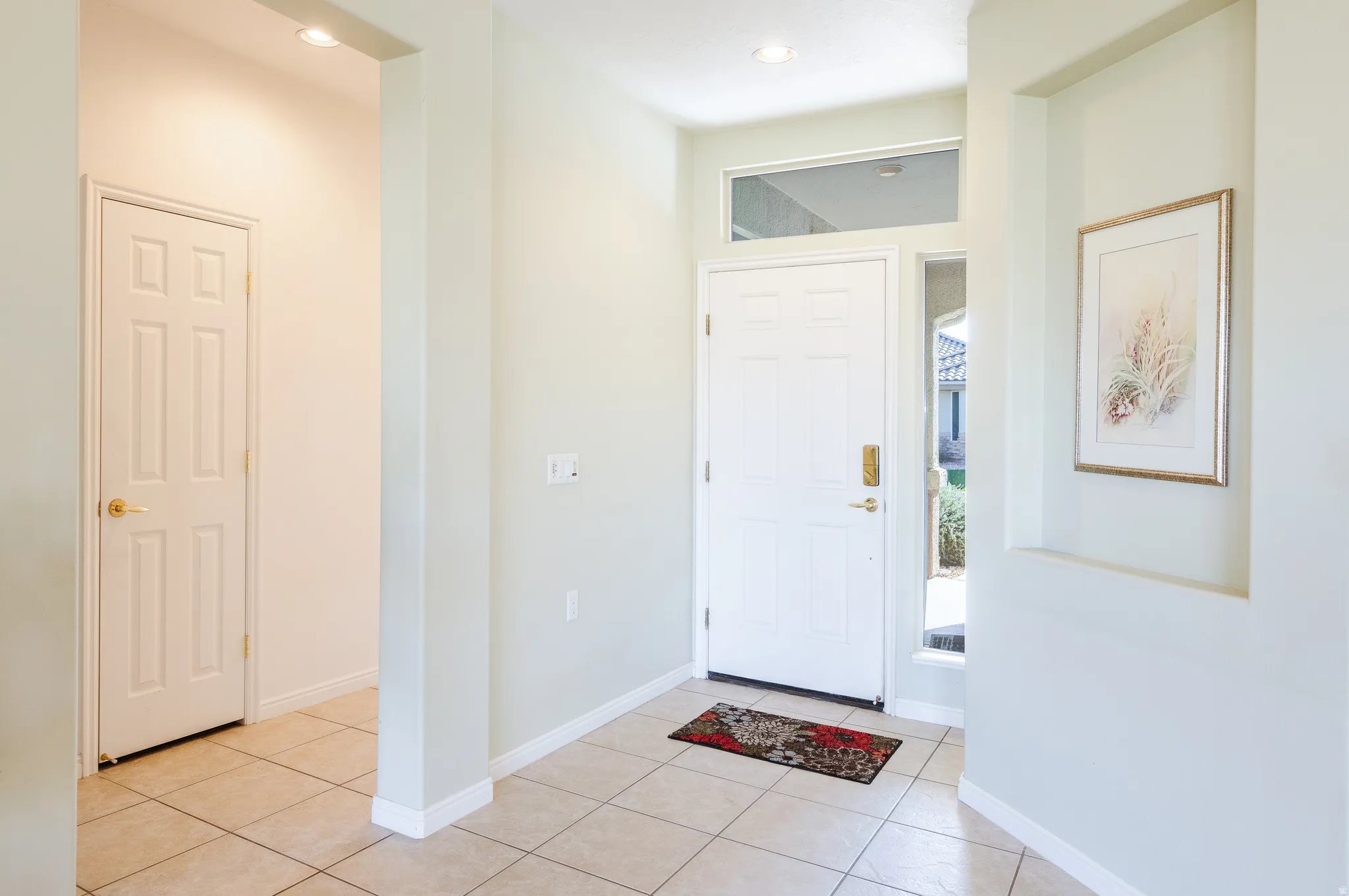 Foyer entrance with light tile patterned flooring and recessed lighting