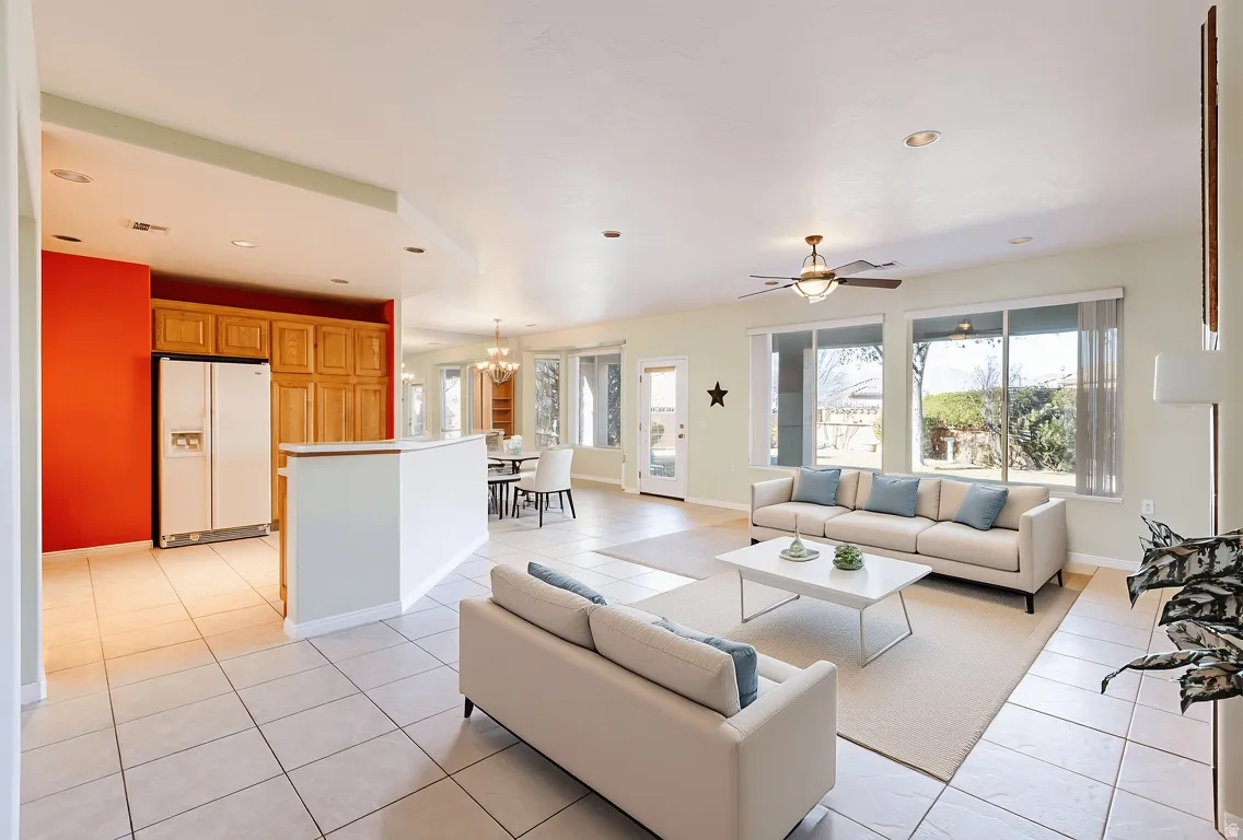 Living area featuring light tile patterned floors, a ceiling fan, healthy amount of natural light, and hanging lights