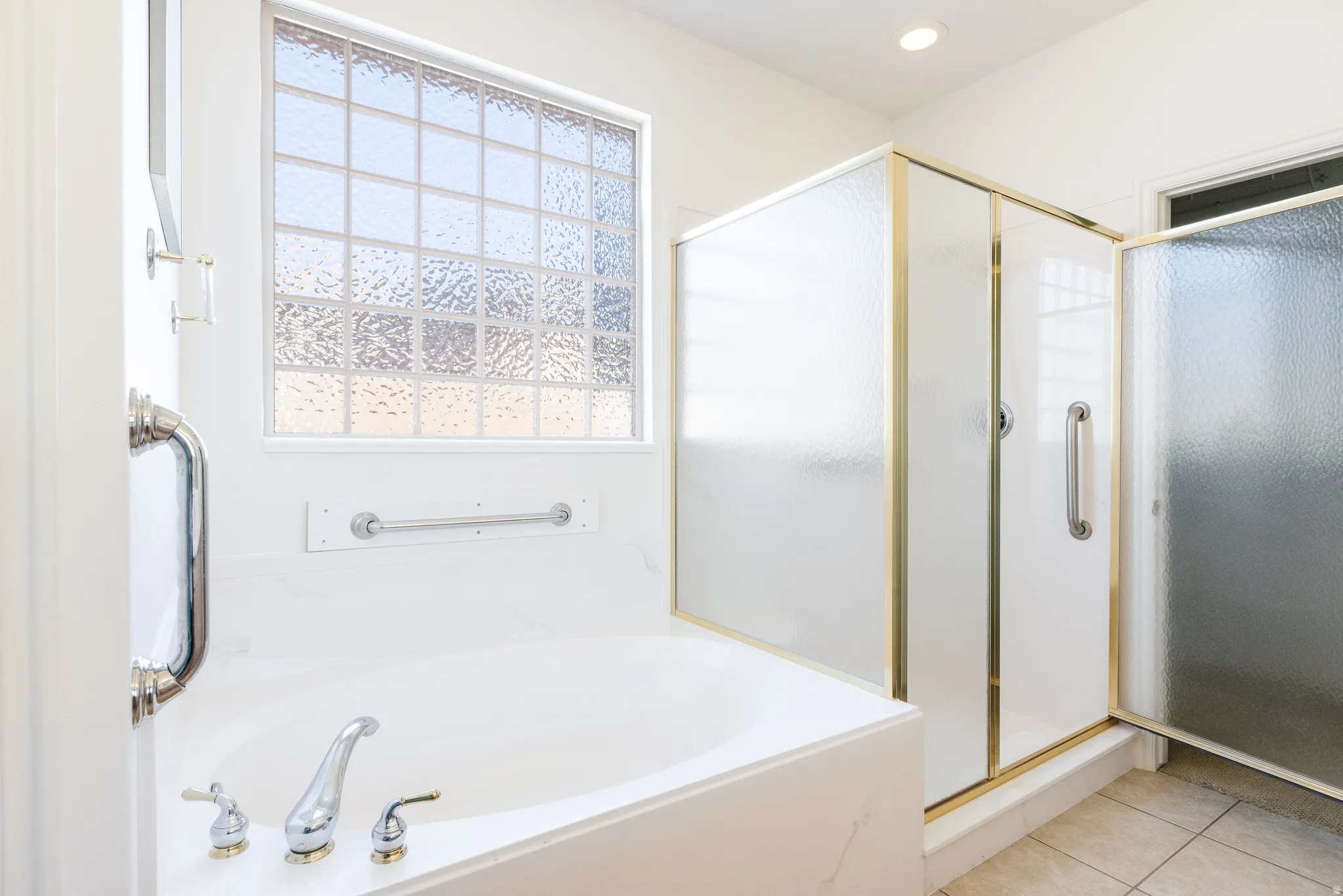 Bathroom featuring a shower stall, a garden tub, light tile patterned floors, and recessed lighting