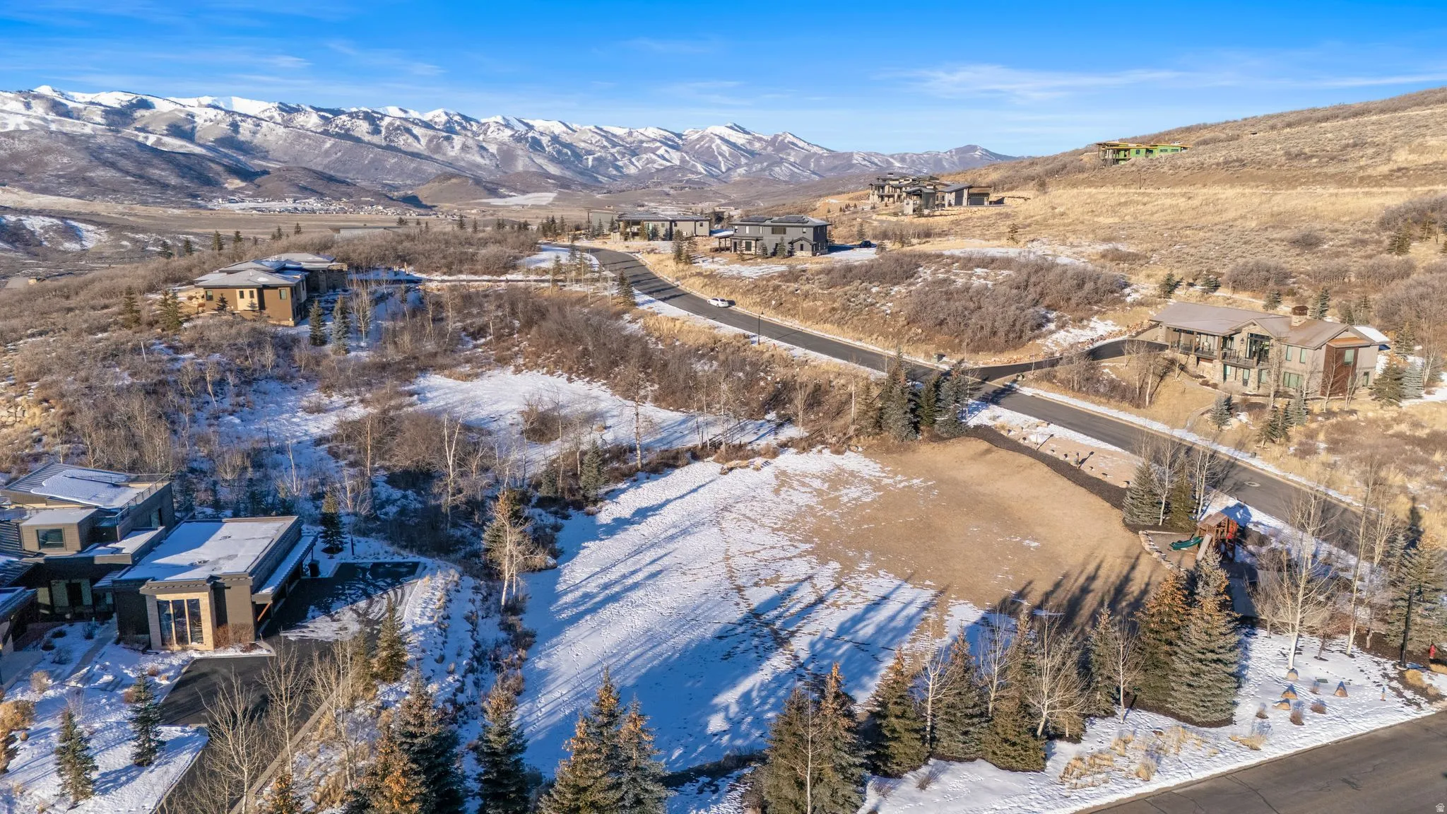 Snowy aerial view with a mountain view and a residential view