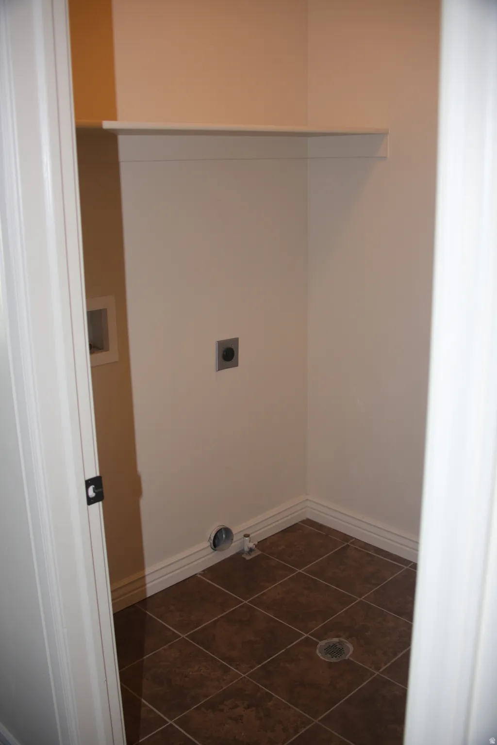Laundry room with hookup for a washing machine and dark tile patterned flooring