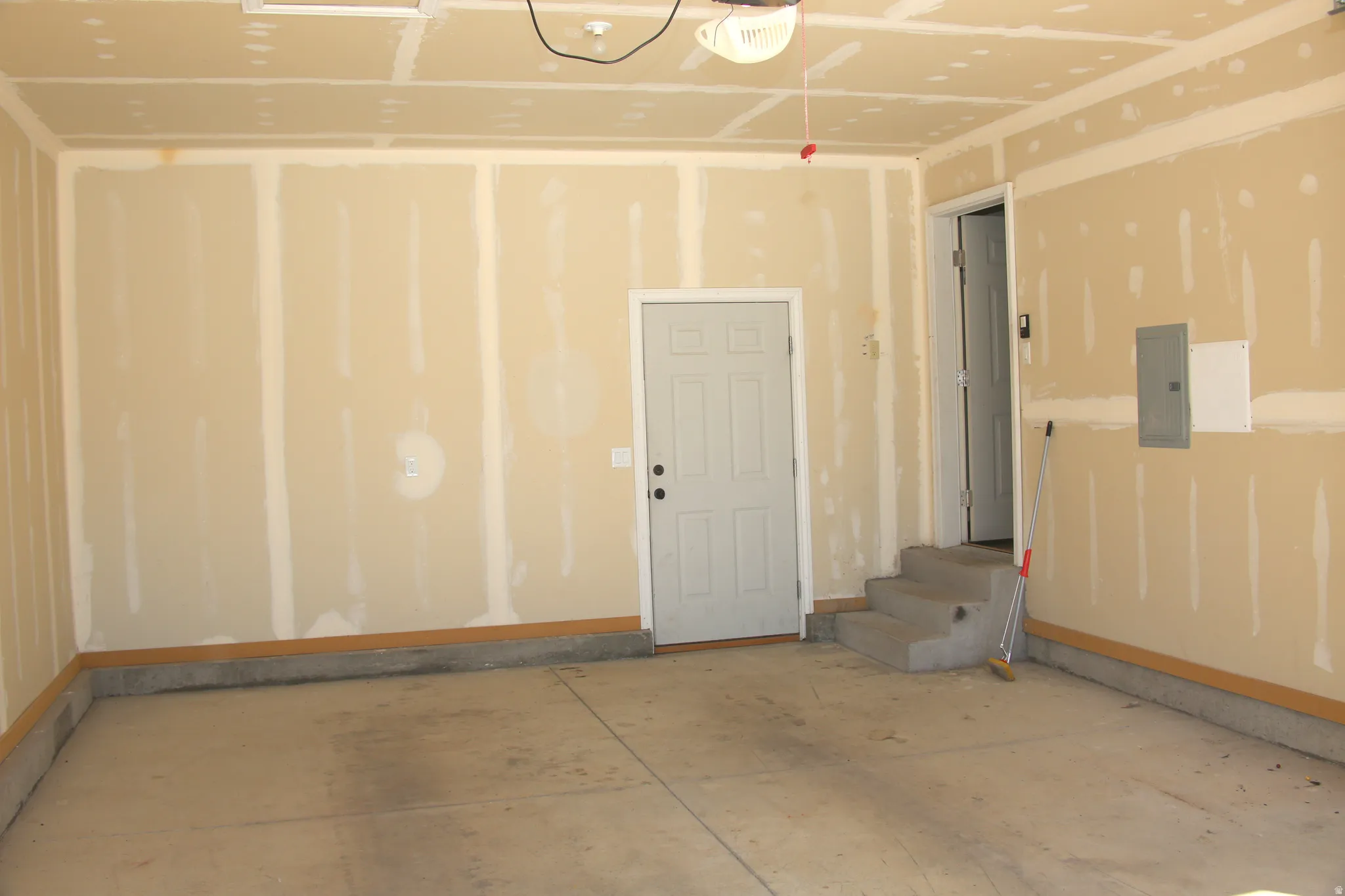 Garage featuring electric panel and a garage door opener