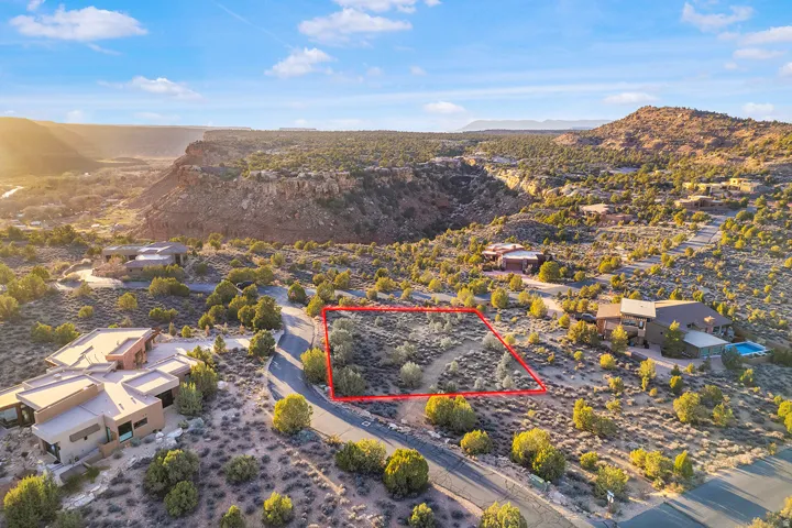 Aerial view of residential area with property boundaries highlighted and a mountain backdrop