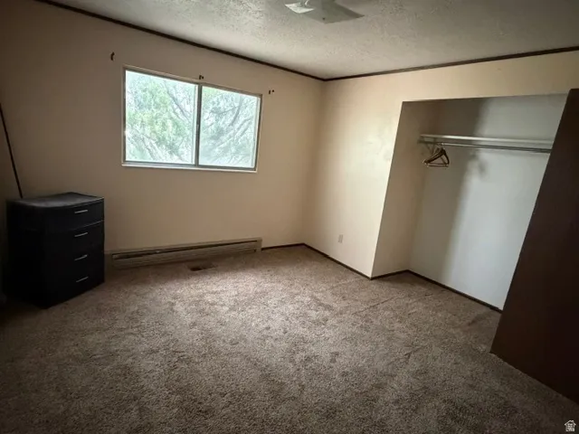 Bedroom featuring neutral wall tones, carpet flooring, a single window, and a built-in closet with a hanging rod