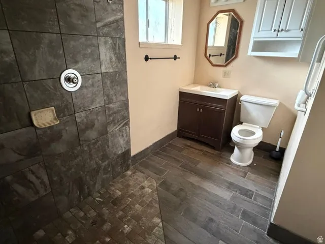 Bathroom featuring a walk-in shower with large format wall tiles and mosaic floor tiles