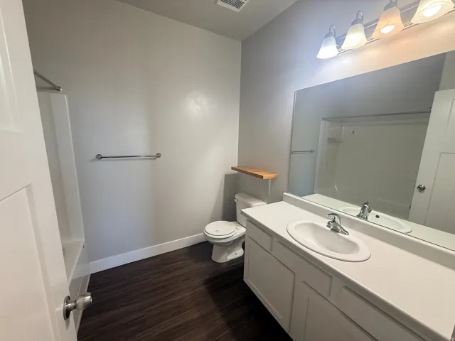 Bathroom featuring vanity, dark wood-type flooring, and shower / tub combination