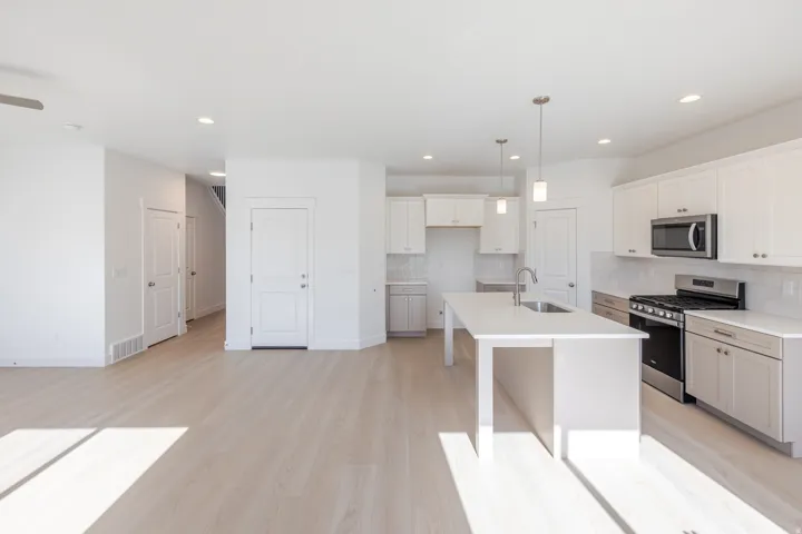 Open-concept living space featuring wood-finish flooring, recessed lighting, and a contemporary kitchen