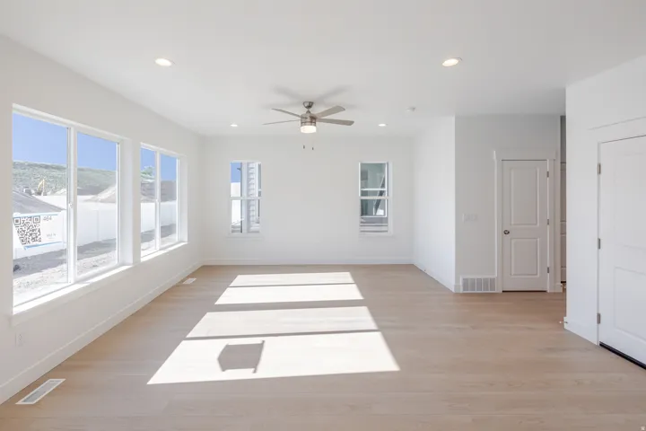 Expansive room featuring wood-finish flooring, recessed lighting, and a ceiling fan