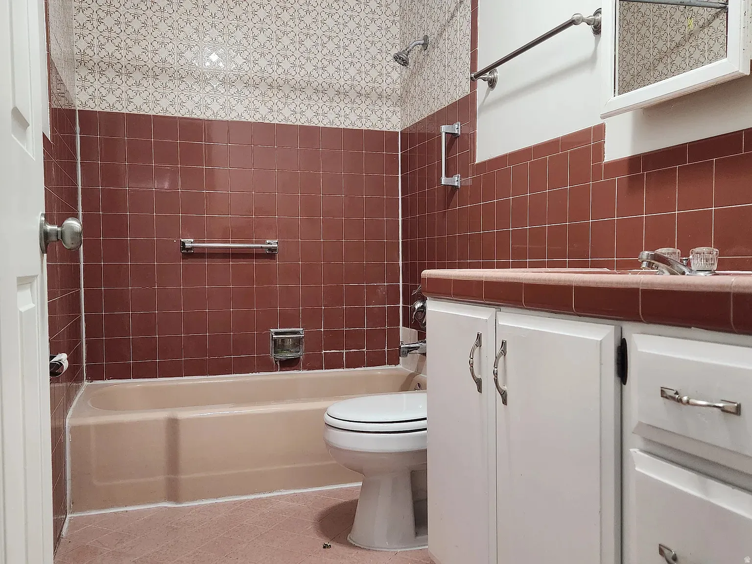 Full bath featuring vanity, shower / bathtub combination, tile walls, and light tile patterned floors