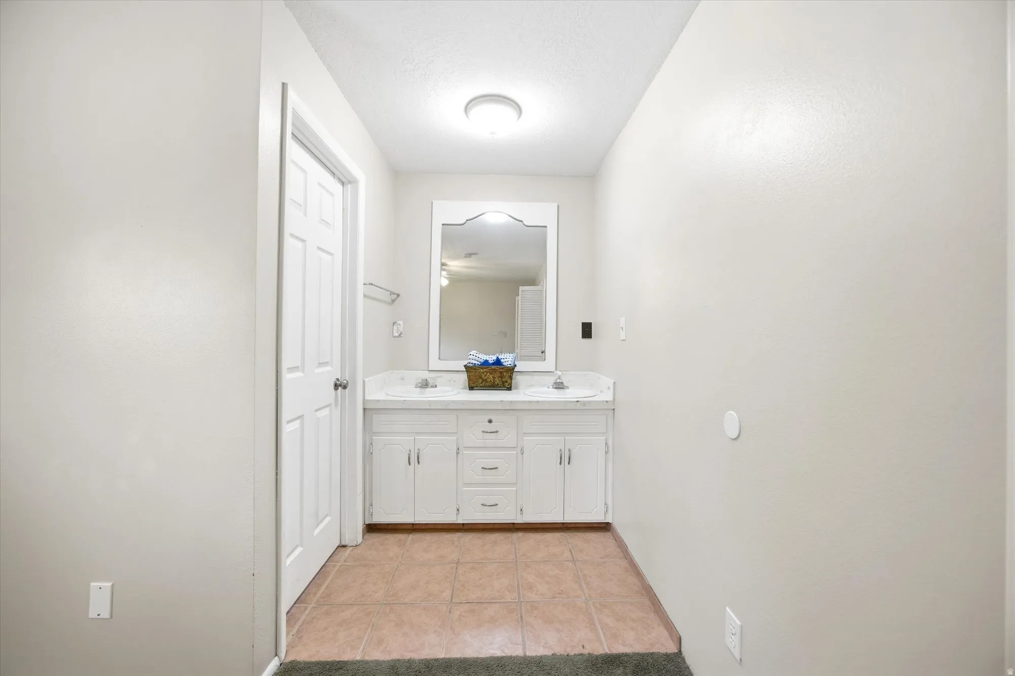 Bathroom with double vanity and light tile patterned flooring