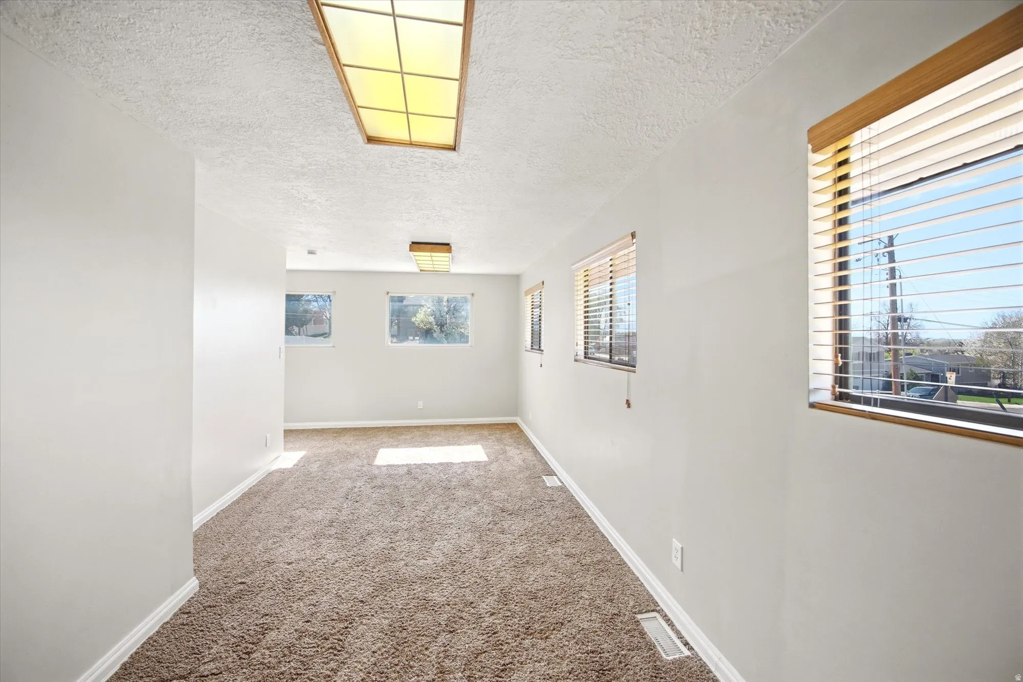 Spare room featuring light carpet and a textured ceiling